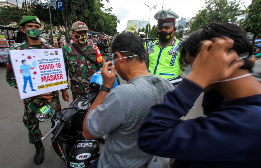 Petugas gabungan TNI dan Polri menjaring warga tidak menggunakan masker.