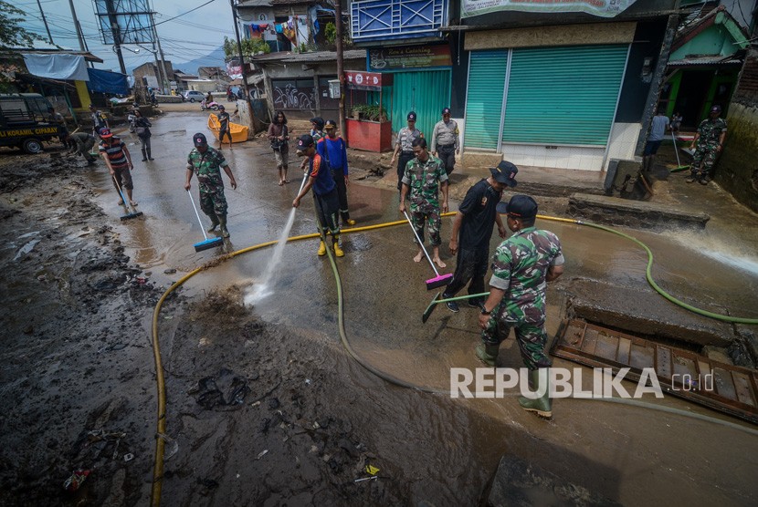 Petugas gabungan TNI, Polri dan Pemadam Kebakaran membersihkan lumpur pascabanjir di Andir, Baleendah, Kabupaten Bandung, Jawa Barat, Senin (22/4/2019). 
