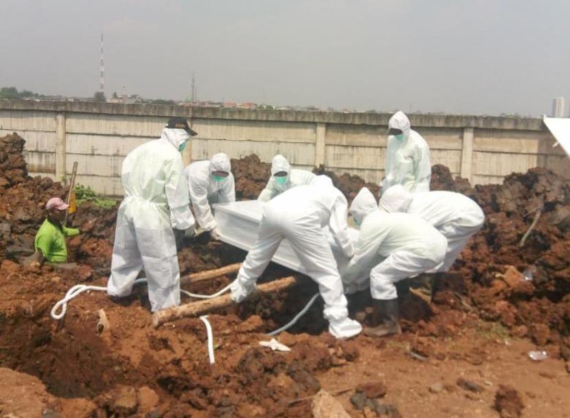 Petugas gali kubur sedang memakamkan jenazah Covid-19 di TPU Rorotan, Kelurahan Rorotan, Jakarta Utara, Jumat (26/3). Pemakaman ini diprioritaskan untuk jenazah Covid-19 yang merupakan warga DKI Jakarta.