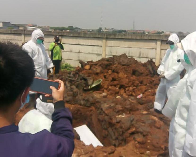 Petugas gali kubur sedang memakamkan jenazah Covid-19 di TPU Rorotan, Kelurahan Rorotan, Jakarta Utara, Jumat (26/3). Pemakaman ini diprioritaskan untuk jenazah Covid-19 yang merupakan warga DKI Jakarta