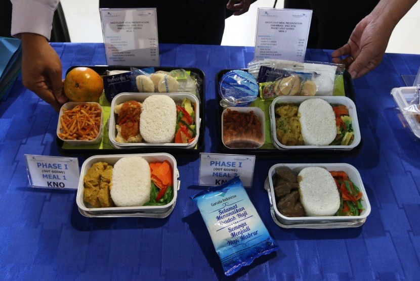 Petugas Garuda Indonesia menunjukan paket makanan untuk jamaah calon haji selama dalam penerbangan saat uji makanan.