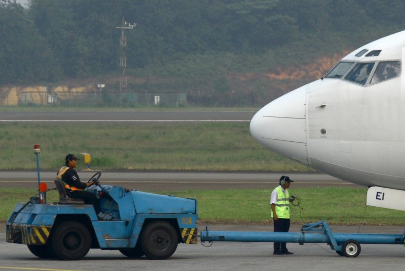 Petugas ground handling menyiapkan salah satu maskapai yang hendak terbang.