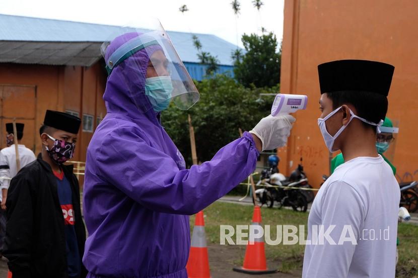 Petugas Gugus Tugas Penanganan Covid-19 memeriksa suhu santri Ponpes Syubbanul Wathon Tegalrejo di pos screening COVID-19 Temanggung, Jawa Tengah, Rabu (22/4). (ilustrasi)