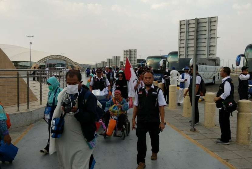 Petugas Haji Daker Bandara menuntun jamaah Kloter 63 Debarkasi Jakarta-Bekasi menuju paviliun Bandara Amir Muhammad bin Abdulaziz, Madinah, Selasa (25/9). Kloter tersebut merupakan kloter terakhir yang dipulangkan ke Tanah Air pada musim haji tahun ini.