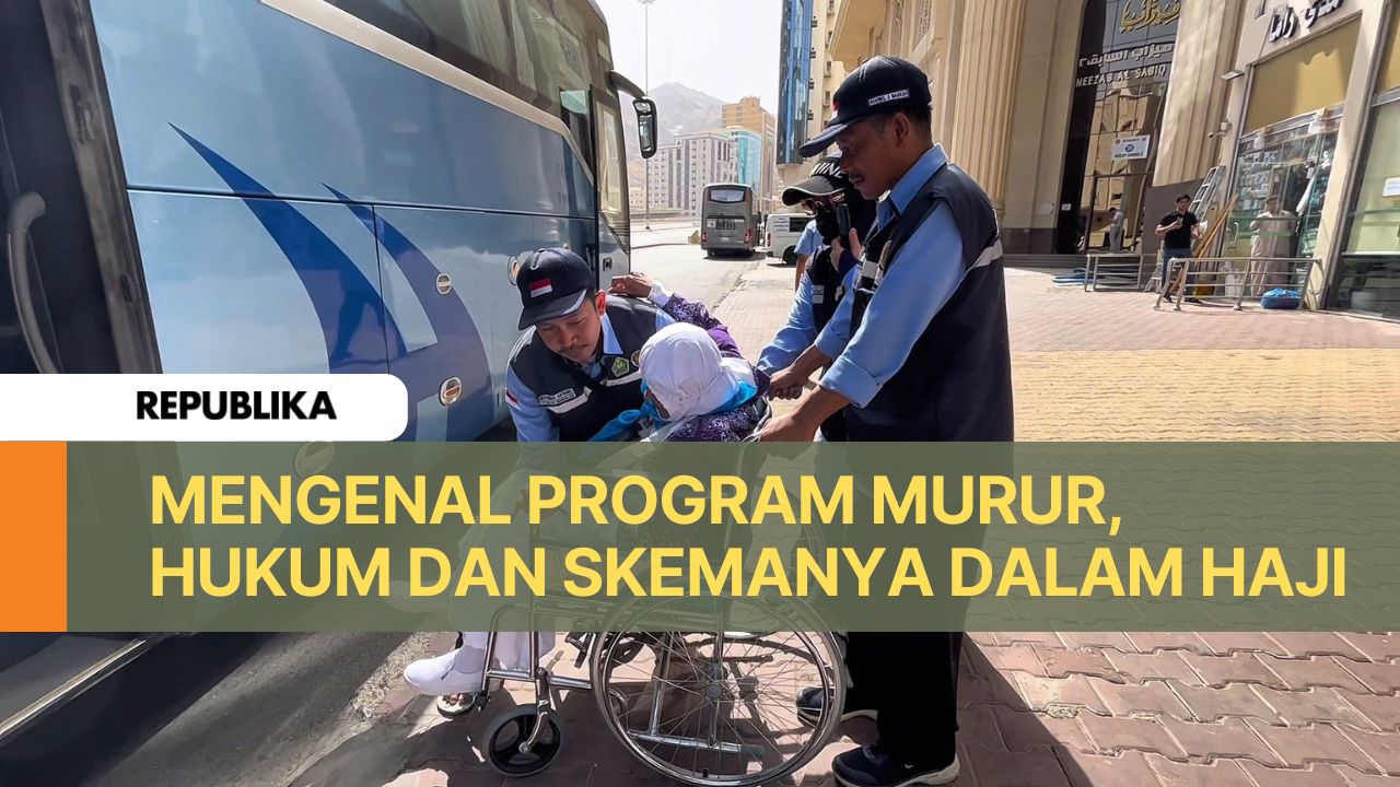 Petugas haji tengah membantu jamaah lansia menaiki kursi roda.