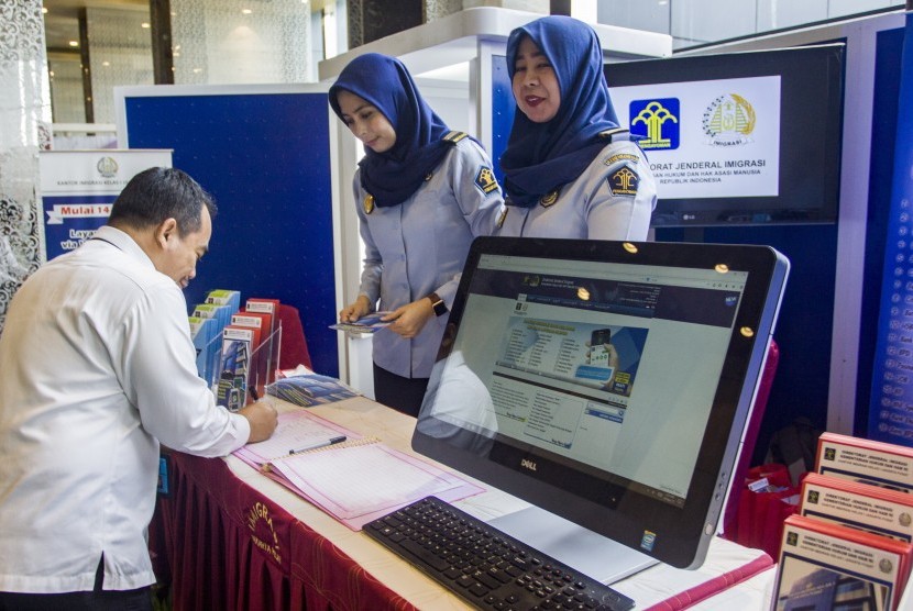 Petugas Imigrasi Jakarta Pusat memberikan informasi kepada pengunjung di stan Kantor Imigrasi Kelas I Jakarta Pusat saat acara Rapat Evaluasi dan Capaian Kemenkumham 2017 di Jakarta, Senin (20/11).