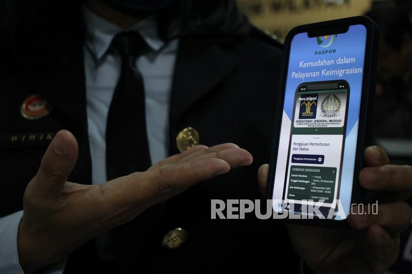 Petugas Imigrasi menunjukkan aplikasi Mobile Paspor atau M-PASPOR di Pusat Pelayanan Terpadu Kanwil Kemenkumham Jawa Timur, Surabaya, Jawa Timur, Kamis (27/1/2022). 