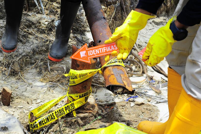 Petugas Inafis Polda Jambi melakukan olah tempat kejadian perkara (TKP) di sumur minyak yang dipasangi garis polisi saat operasi penertiban di Taman Hutan Raya Sultan Thaha Syaifuddin, Batanghari, Jambi. 