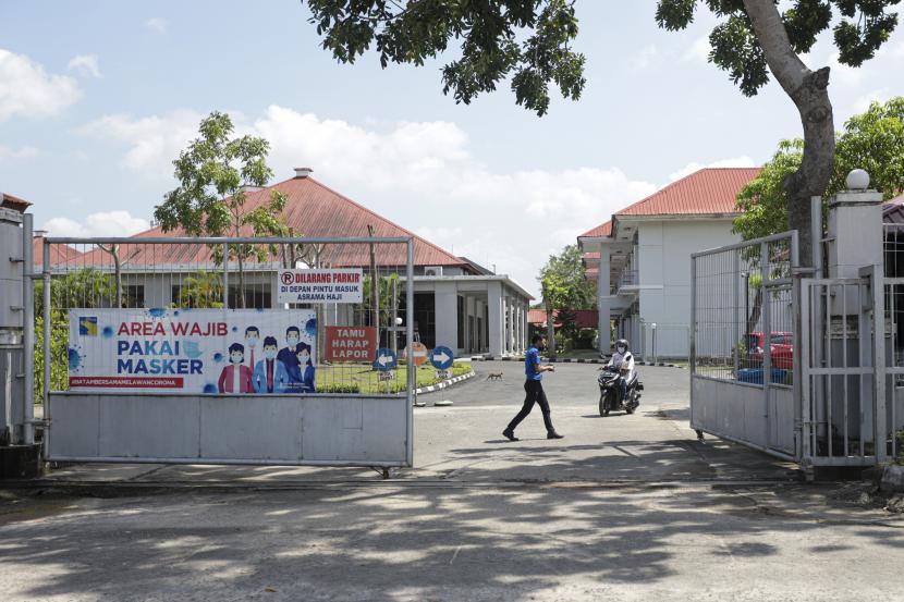 Petugas jaga berjalan di dekat gerbang masuk area Gedung Asrama Haji Batam, Kepulauan Riau, Kamis (16/12/2021). Kemenag Riau Tetapkan Perusahaan Pemenang Lelang Katering Calhaj