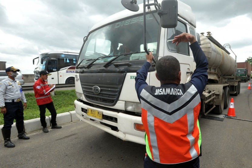 Petugas Jasa Marga dan Dinas Perhubungan mengarahkan truk yang membawa muatan untuk ditimbang saat Operasi tertib kendaraan bermuatan lebih yang berlangsung 31 Januari-6 Februari 2017, di Jalan Tol Jakarta-Cikampek KM 41, Cikarang, Jawa Barat, Senin (6/2).