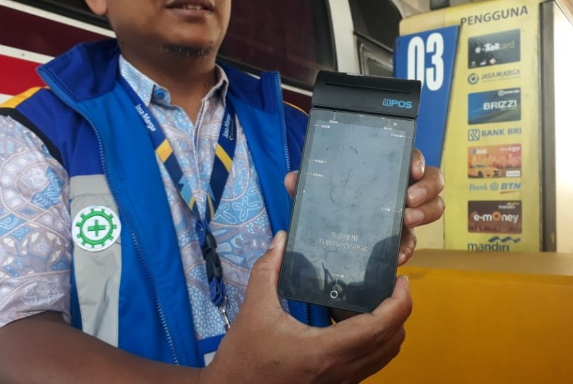 Petugas Jasa Marga Purbaleunyi menunjukkan mobile reader uang elektronik, Sabtu (9/6). Alat itu akan digunakan untuk mempercepat transaksi di gerbang tol. 