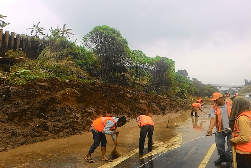Petugas Jasa Marga sedang membersihkan tanah bekas longsoran di tol Cipularang KM 118, Ahad (10/4), di wilayah Desa Sukatani Kecamatan Padalarang, Kabupaten Bandung Barat.