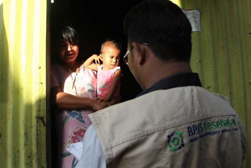 Petugas kader JKN-KIS berkunjung ke rumah peserta BPJS Kesehatan di kawasan pesisir di Kelurahan Lapulu, Kendari, Sulawesi Tenggara, Senin (13/8).