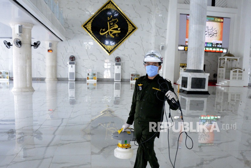 Petugas Kantor Kesehatan Pelabuhan (KKP) bersiap menyemprotkan cairan disinfektan di area Masjid Agung Syekh Yusuf, Kabupaten Gowa, Sulawesi Selatan, Senin (16/3/2020).