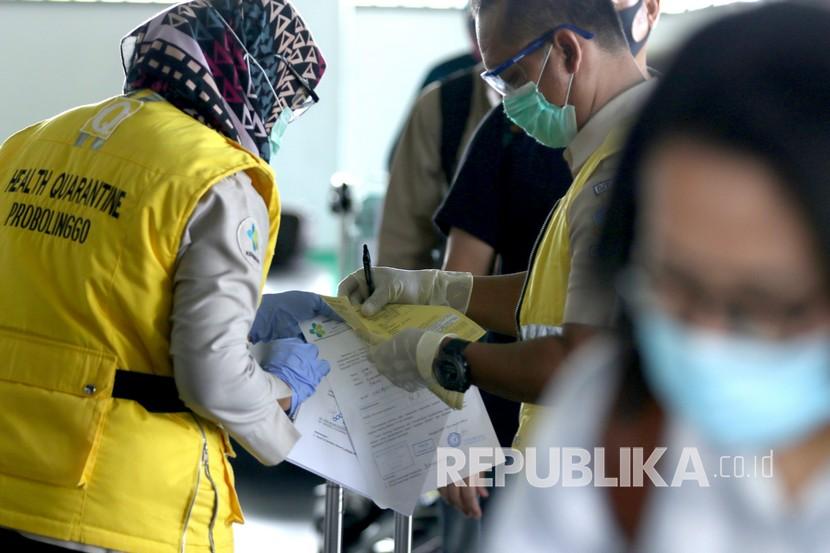 Petugas Kantor Kesehatan Pelabuhan memeriksa berkas persyaratan penumpang yang baru tiba di Bandara Banyuwangi, Jawa Timur, Sabtu (16/5/2020). Setelah aktivitas penerbangan ditutup untuk menghindari penyebaran wabah COVID-19, mulai hari ini penerbangan kembali dibuka dengan menerapkan protokol pencegahan penularan COVID-19. 