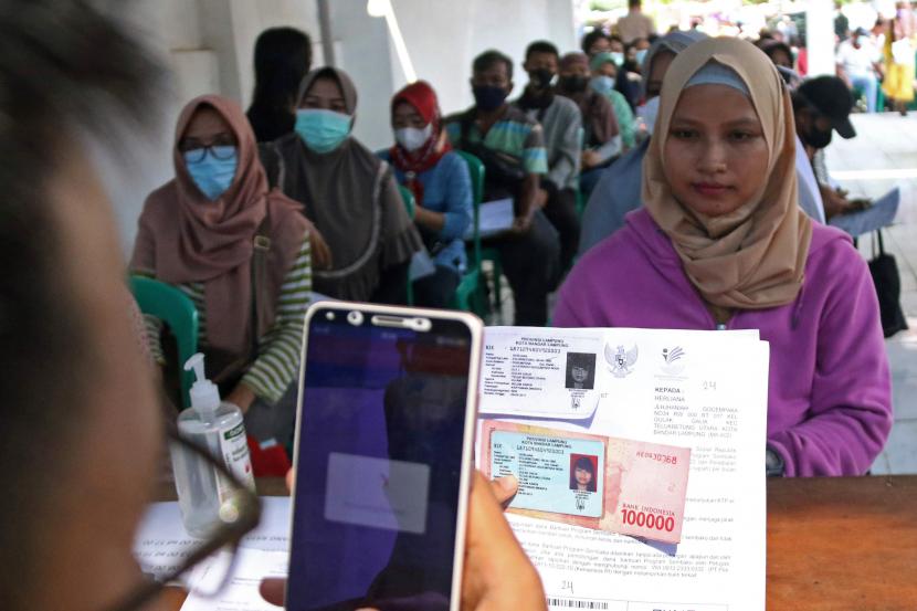 Petugas Kantor Pos memotret warga penerima bantuan sosial atau Bansos di kantor Pos Bandar Lampung, Lampung, Kamis (14/4/2022). ilustrasi
