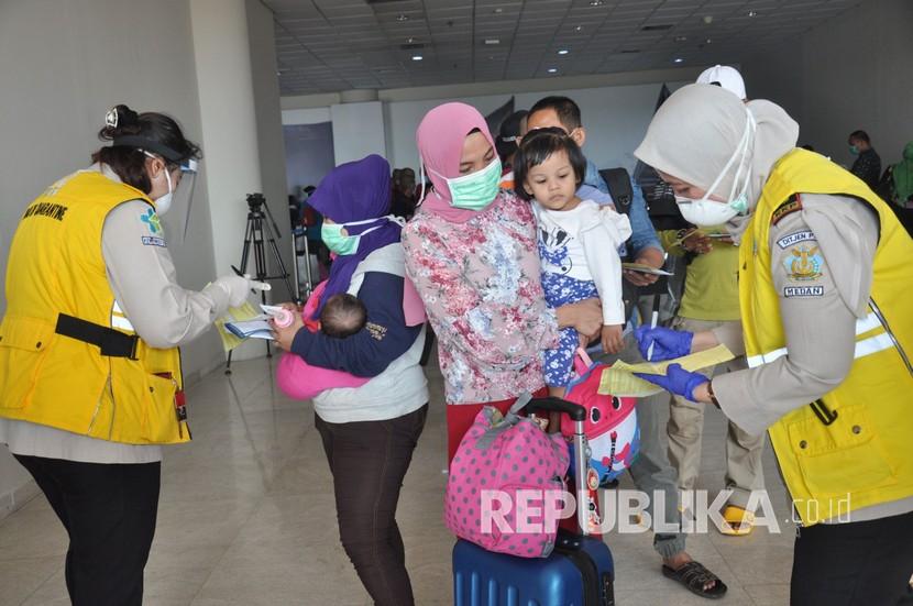 Petugas Karantina Kemenkes memeriksa surat kesehatan kewaspadaan para Tenaga Kerja Indonesia (TKI) dari Malaysia saat tiba di Bandara Internasional Kualanamu Kabupaten Deliserdang, Sumatera Utara, Kamis (9/4/2020). Sebanyak 134 orang TKI yang terdampak 