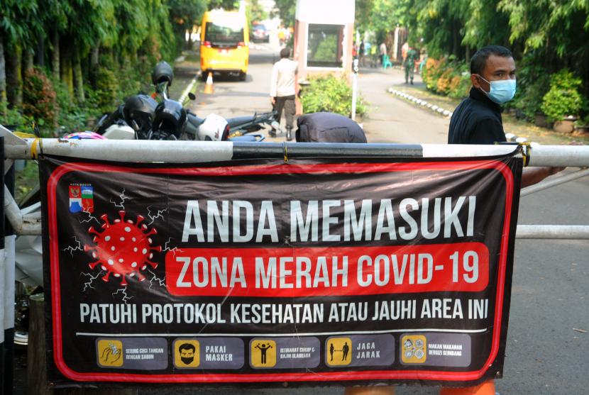Petugas keamanan berjaga di depan gerbang masuk Perumahan Griya Melati, Kelurahan Bubulak, Kota Bogor, Jawa Barat, Kamis (20/5/2021). Sebanyak 35 warga di perumahan tersebut positif terpapar COVID-19 setelah salah satu warganya terkonfirmasi positif COVID-19 sepulang dari luar kota saat sebelum Lebaran sehingga warga melakukan isolasi mandiri dan akses masuk perumahan ditutup sementara.