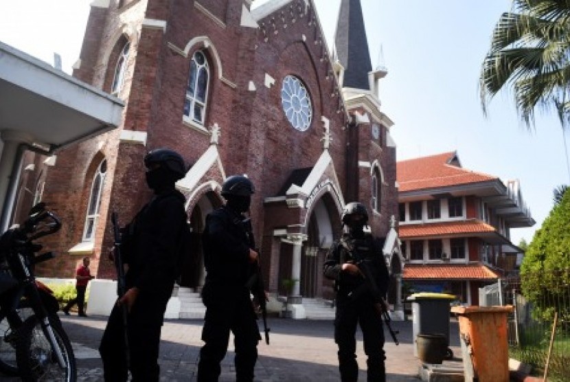 Petugas keamanan berjaga di depan gereja saat misa di Gereja Katolik Kelahiran Santa Perawan Maria, Surabaya, Jawa Timur, Ahad (20/5). Pengamanan tersebut guna mengantisipasi dan memberikan rasa aman kepada jemaat yang melaksanakan kebaktian dan misa sepekan pascaledakan bom di tiga gereja di Surabaya. 