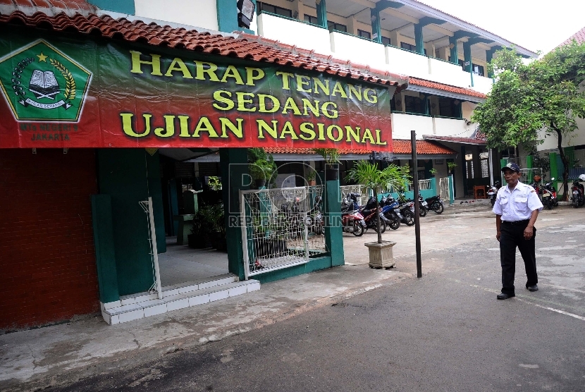 Petugas keamanan berjaga dilingkungan saat Ujian Nasional berlangsung di sekolah MTSN 9, Johar Baru, Jakarta Pusat, Senin (4/5).  (Republika/Tahta Aidilla)