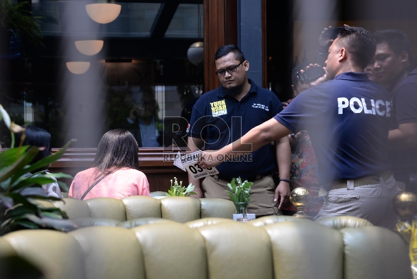 Petugas keamanan berjaga saat proses pra-rekonstruksi di Cafe Olivier, Mal Grand Indonesia, Jakarta, Senin (11/1).  (Republika/Yasin Habibi)