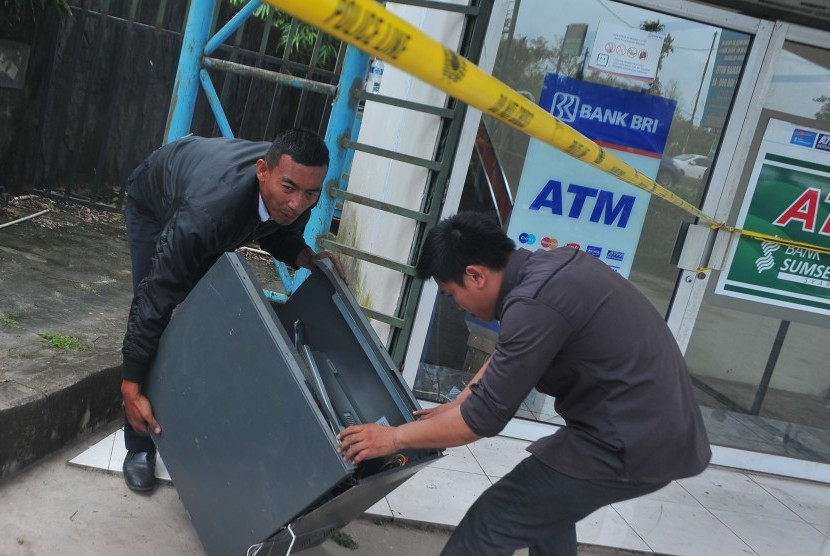 Petugas keamanan dan petugas bank mengangkat sisa mesin Anjungan Tunai Mandiri (ATM) yang dibobol di Jalan Soekarno Hatta Palembang, Sumsel, beberapa waktu lalu.