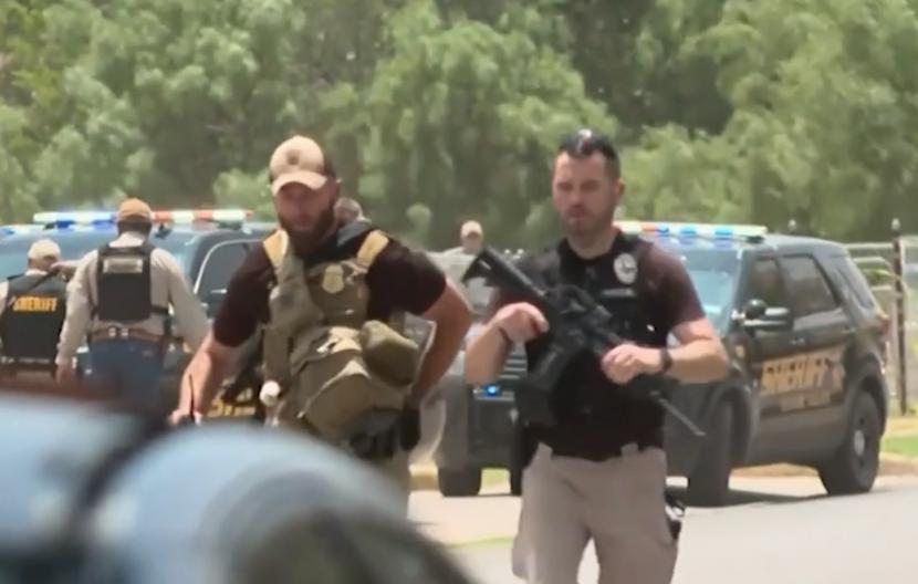 Petugas keamanan di Texas, AS saat mengevakuasi korban penembakan massal di Sekolah Dasar  Robb, Uvalde, Texas. 