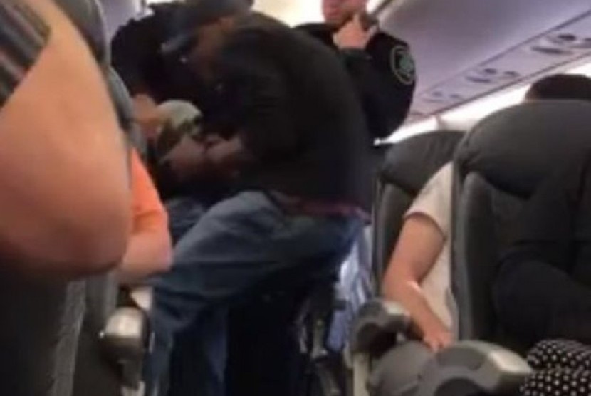 Petugas keamanan memaksa salah satu penumpang United Airlines, David Dao turun dari pesawat dengan menyeretnya, Ahad (9/4).