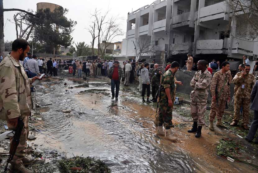  Petugas keamanan memeriksa lokasi bom mobil yang  menargetkan Kedubes Prancis di Tripoli, Libya, Selasa (23/4).    (AP/Abdul Majeed Forjani)