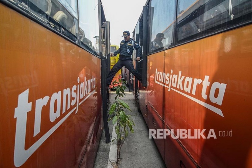 Petugas keamanan mengecek kondisi Bus Transjakarta yang terparkir di Terminal Pulogadung, Jakarta Timur, Jum'at (23/8/2019). Menurut petugas sebanyak 36  Bus Transjakarta yang rusak sudah terparkir sejak Oktober 2017. 