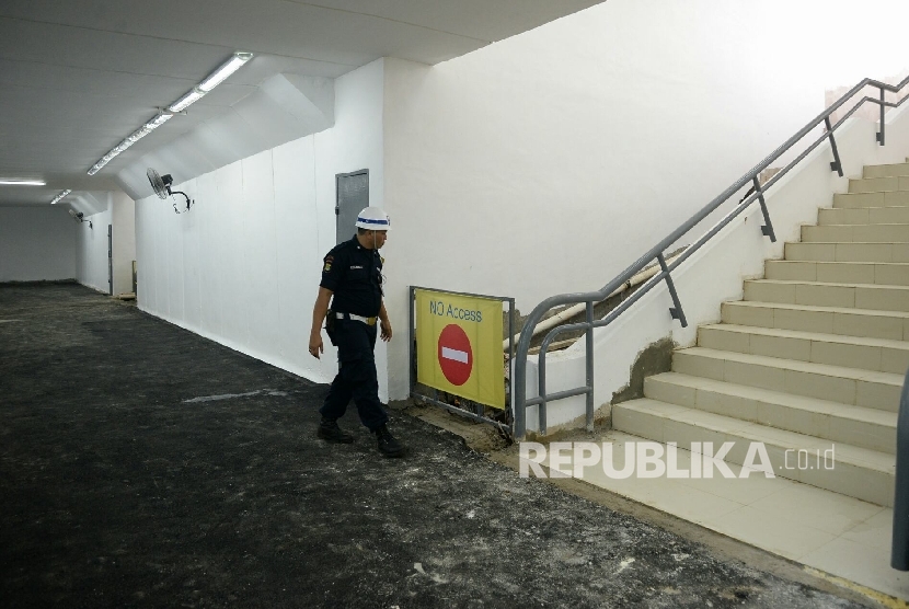 Petugas keamanan mengecek kondisi terkini terowongan penyebrangan orang di Stasiun Manggarai, Jakarta, Jumat (25/11). 