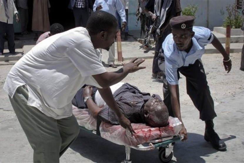 Petugas keamanan mengevakuasi korban ledakan yang terjadi di Teater Nasional, Mogadishu, Somalia,Rabu (4/4),   (Foto: Mohamed Sheikh Nor/AP)