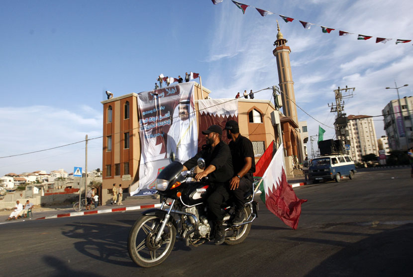  Petugas keamanan Palestina mengendarai sepeda motor di depan sebuah spanduk Emir Qatar Sheikh Hamad bin Khalifa al-Thani, di sebuah masjid di Kota Gaza,Palestina (Ilustrasi)