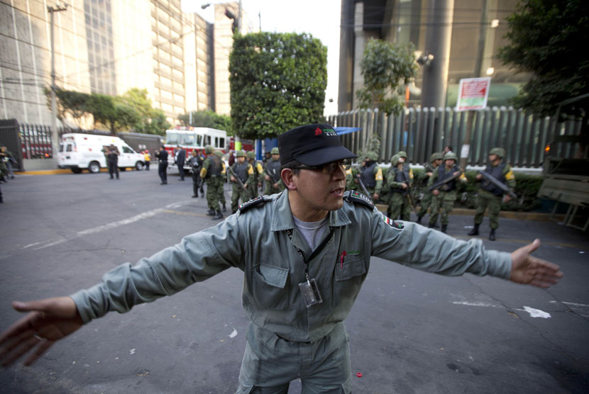  Petugas keamanan Pemex,perusahaan minyak milik negara, menghalau para jurnalis agar menjauh dari lokasi ledakan di Gedung Pemex di Mexico City, Kamis (31/1).  (AP/Eduardo Verdugo)