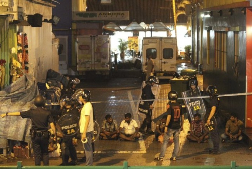 Petugas keamanan Singapura mengamankan sejumlah orang terkait kerusuhan di kawasan Little India pada Ahad (8/12/2013)