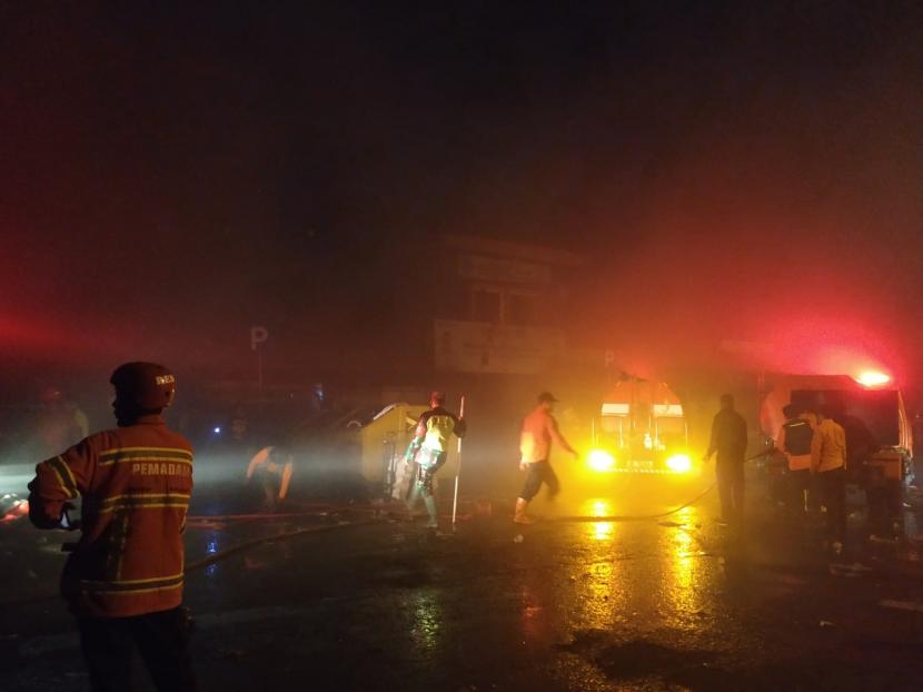 Petugas kebakaran berusaha memadamkan api yang membakar puluhan kios di Pasar Ciawi, Kabupaten Tasikmalaya, Ahad (15/8). 