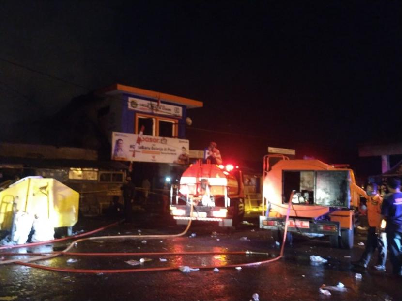 Petugas kebakaran berusaha memadamkan api yang membakar puluhan kios di Pasar Ciawi, Kabupaten Tasikmalaya, Ahad (15/8). 