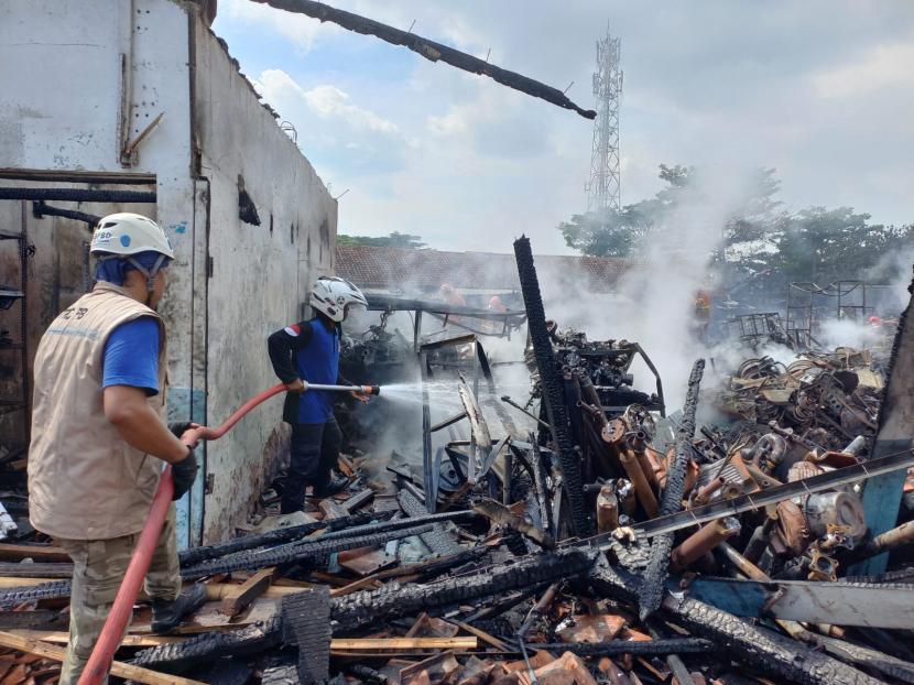 Petugas mendinginkan sisa kebakaran di Pasar Besi Cikurubuk, Kecamatan Mangkubumi, Kota Tasikmalaya, Rabu (4/1/2023). 