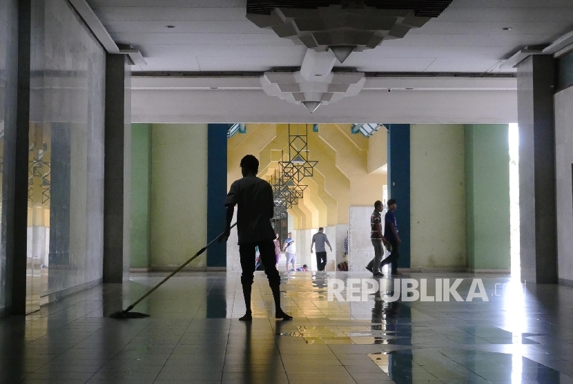   Petugas kebersihan Islamic Center Jakarta, tengah membersihkan bagian dari masjid tersebut, Ahad (21/8).(Republika/ Darmawan)