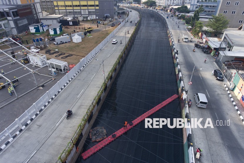 Petugas kebersihan membersihkan sampah di Kali Item yang telah ditutup jaring di dekat Wisma Atlet Kemayoran, Jakarta, Jumat (20/7).