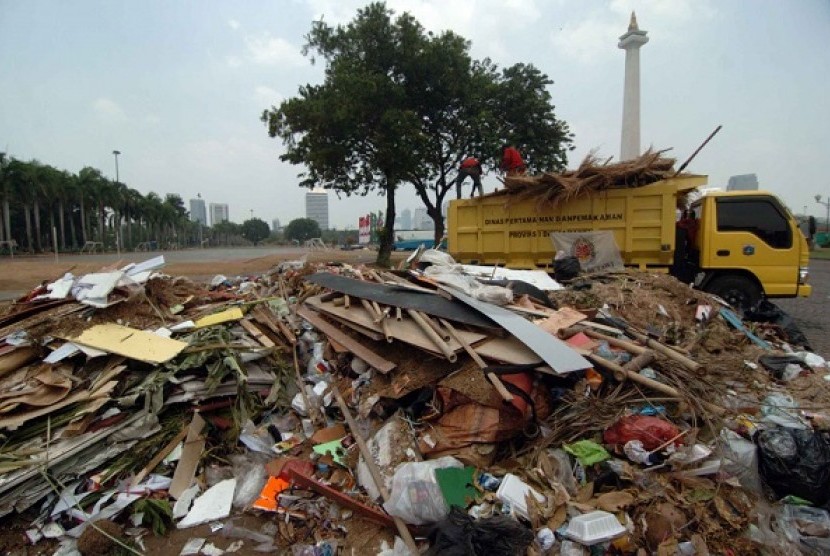 Petugas kebersihan membersihkan sampah yang berada di silang Monas, Jakarta Pusat, Senin (15/9). Lebaran Betawi yang diadakan sejak hari Sabtu hingga Ahad (14/9) ini menimbulkan sampah yang menumpuk, sehingga merusak keindahan monas.