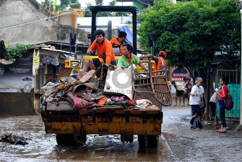   Petugas kebersihan mengangkut sampah-sampah yang menumpuk di kampung Melayu Besar, Jakarta Selatan, Selasa (14/1). (Republika/Prayogi)