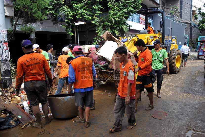   Petugas kebersihan mengangkut sampah-sampah yang menumpuk di kampung Melayu Besar, Jakarta Selatan, Selasa (14/1). (Republika/Prayogi)