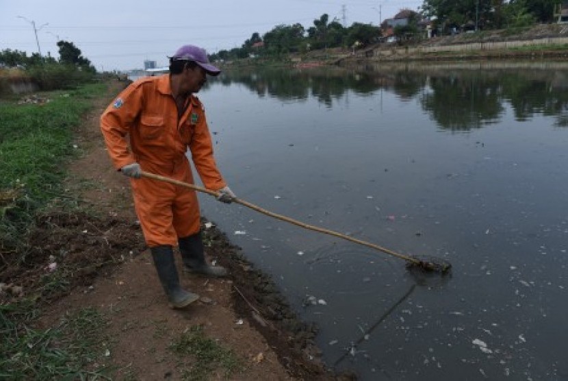 Petugas kebersihan mengeruk lumpur di Kanal Banjir Timur (KBT), Pulogebang, Jakarta, Senin (28/9).