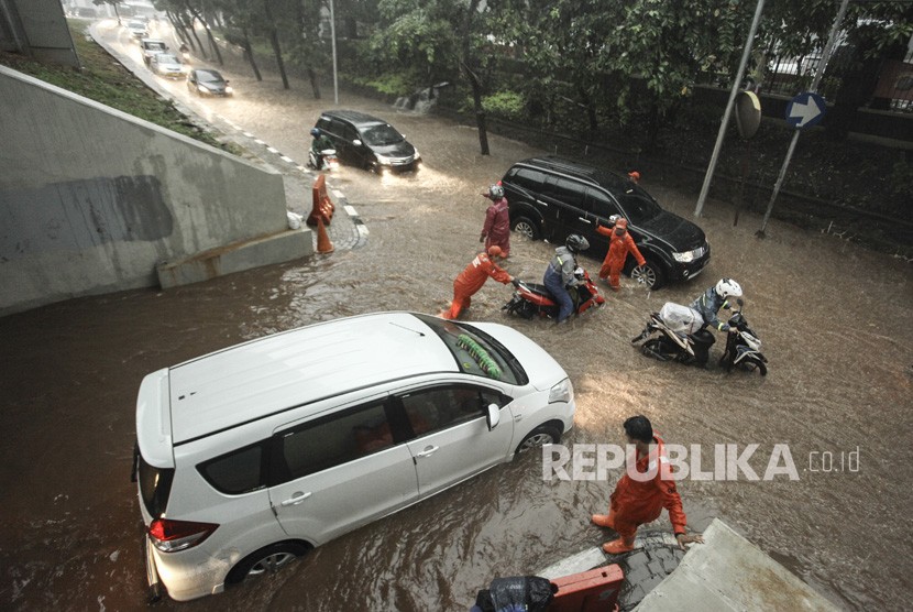 Petugas Kebersihan Pemprov DKI Jakarta mencoba membantu kendaraan yang akan melintasi genangan air yang menggenangi kawasan Semanggi di Jakarta, Senin (11/12). (Ilustrasi)