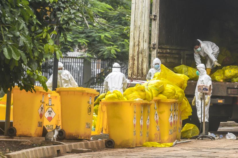 Petugas kebersihan rumah sakit Covid-19 memasukan limbah B3 ke dalam truk sampah di Jakarta.