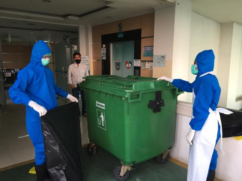 Petugas Kebersihan Rumah Sakit Umum Kota Tangerang Selatan (Tangsel) mengumpulkan sampah medis bekas pasien Covid-19, Ahad (16/4).