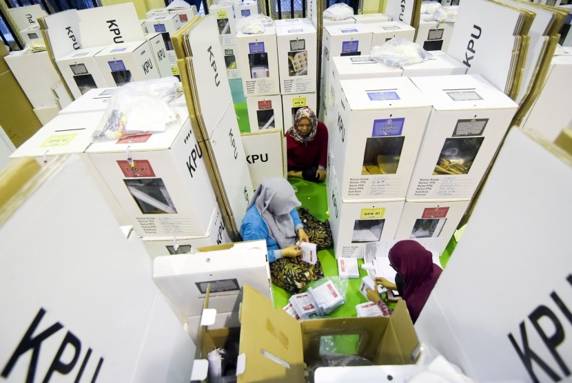 Petugas Kelompok Panitia Pemungutan Suara (KPPS) memeriksa kelengkapan logistik Pemilu sebelum didistribusikan ke kelurahan di gudang logistik KPU Jakarta Pusat, GOR Tanah Abang, Jakarta, Senin (15/4/2019).