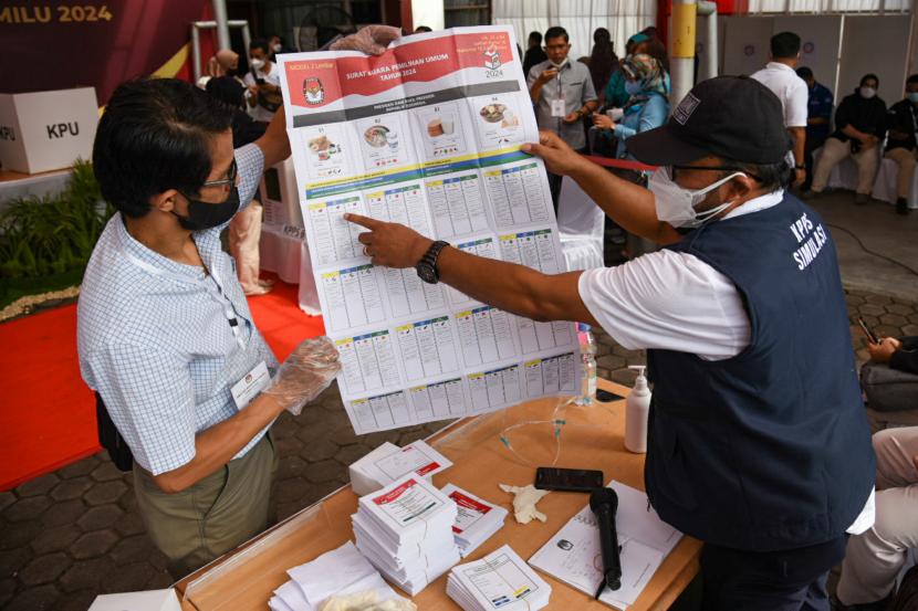 Petugas Kelompok Penyelenggara Pemungutan Suara (KPPS) melayani pemilih saat mengikuti simulasi pemungutan dan penghitungan suara pemilu. 