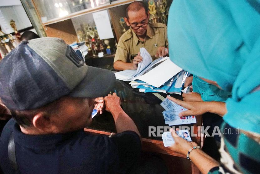 Petugas Kelurahan melayani warga saat pengambilan KTP-el di Kelurahan Bakti Jaya Depok, Jawa Barat, Senin (4/2).